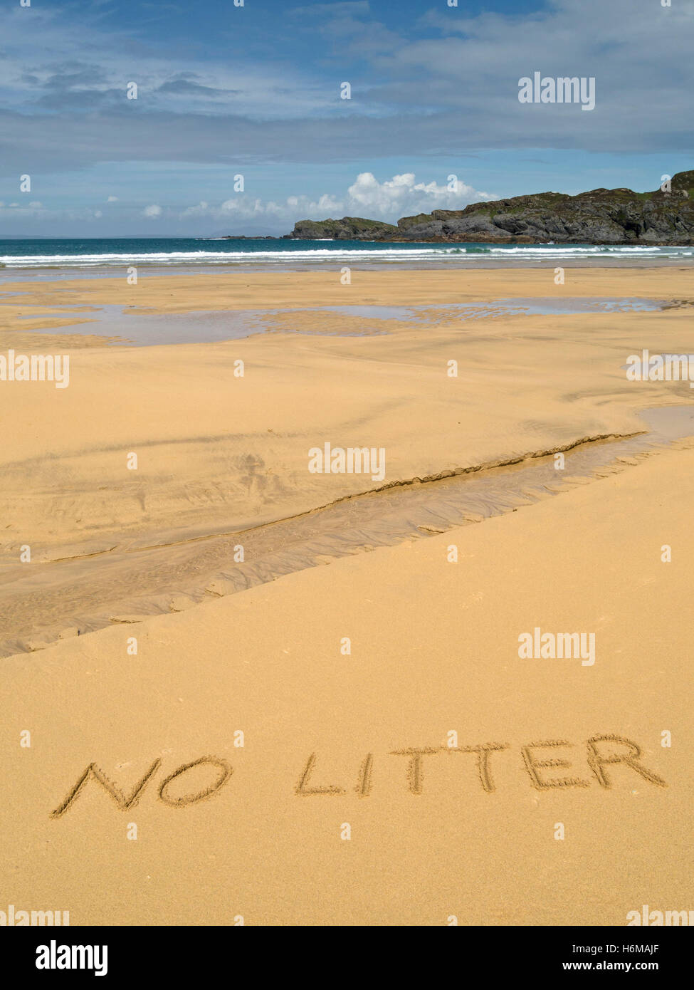 The words 'no litter' written in golden yellow sand of remote and perfectly clean Kiloran Bay beach, Colonsay, Scotland, UK. Stock Photo