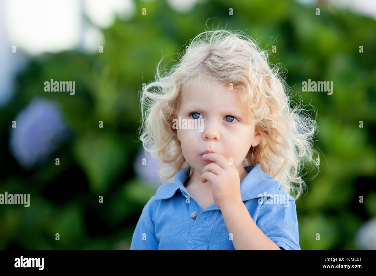 Beautiful Boy Three Year Old With Long Blond Hair On A Sunny Day