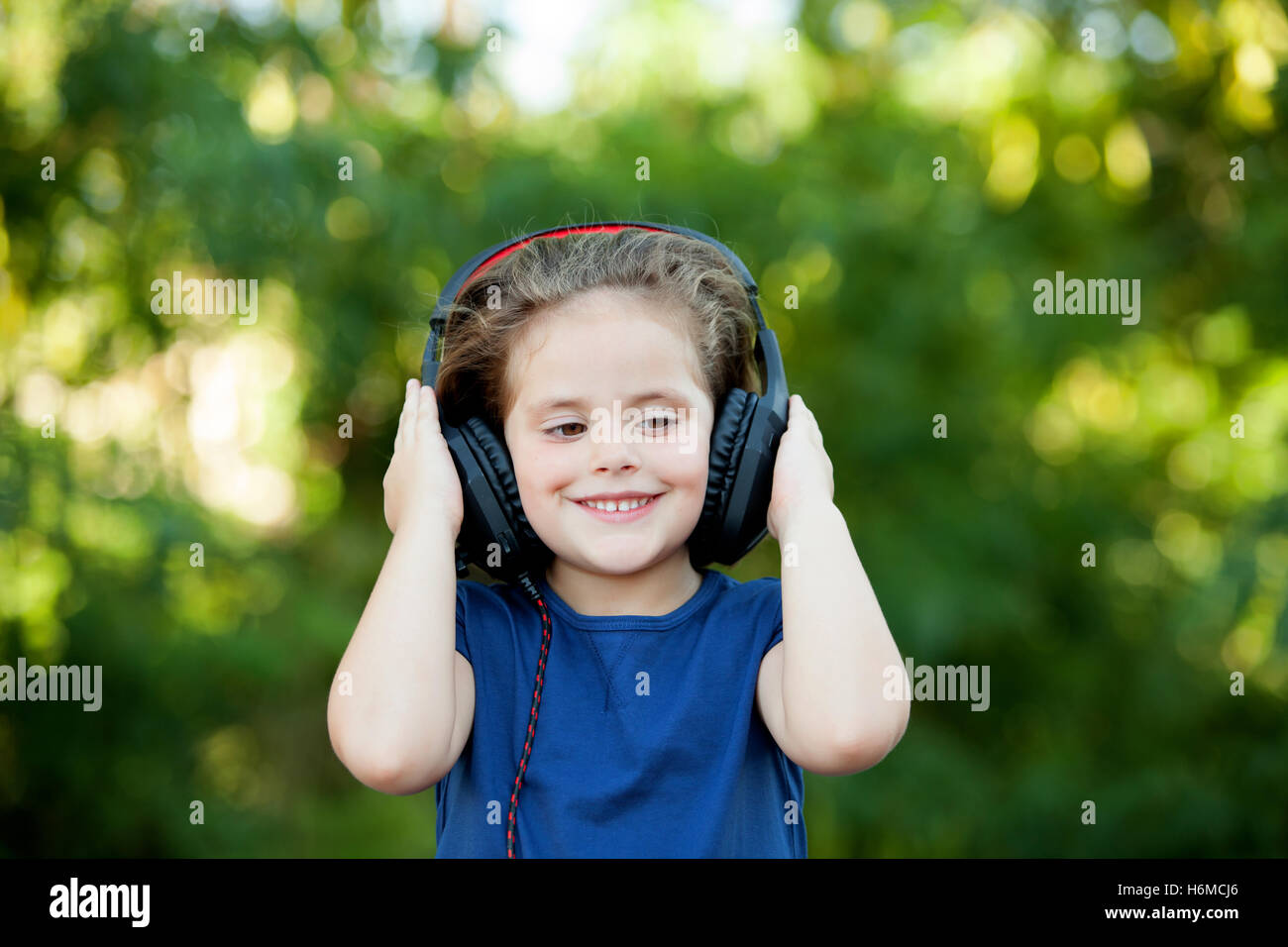 Little girl with headphones on a park Stock Photo - Alamy