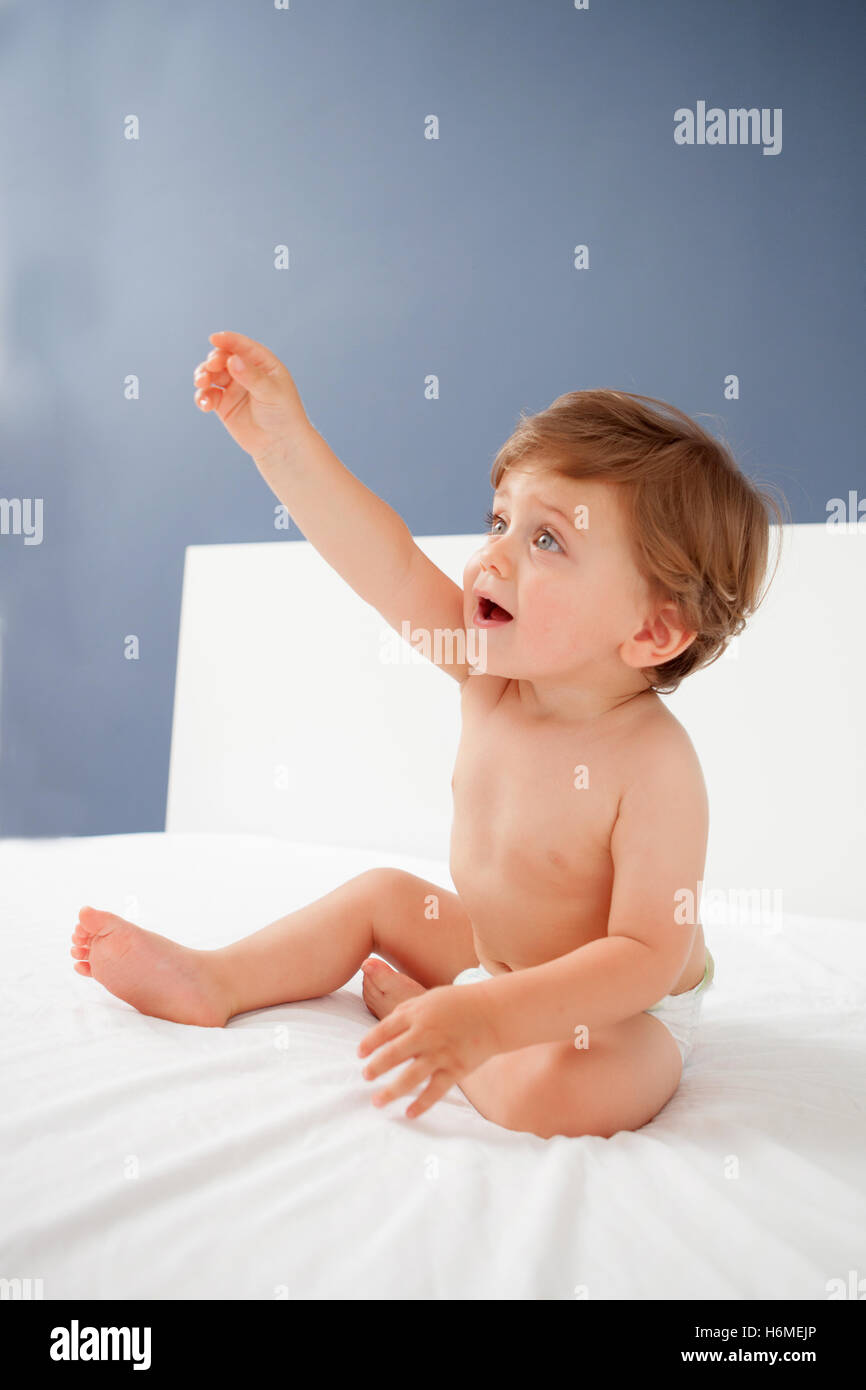 Baby with one years old getting out of bed doing gestures Stock Photo ...