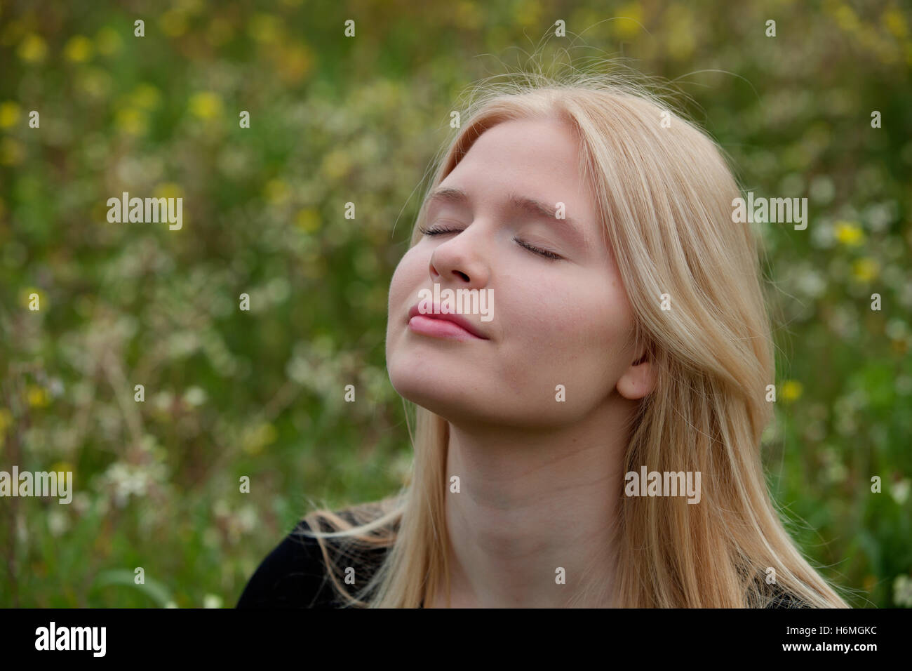 Pretty blond girl with eyes closed enjoying nature Stock Photo - Alamy