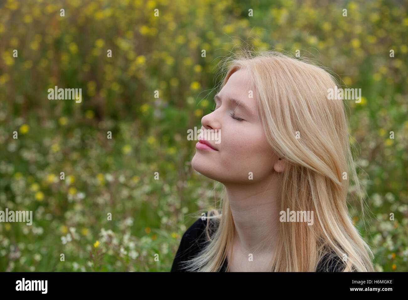 Pretty blond girl with eyes closed enjoying nature Stock Photo - Alamy