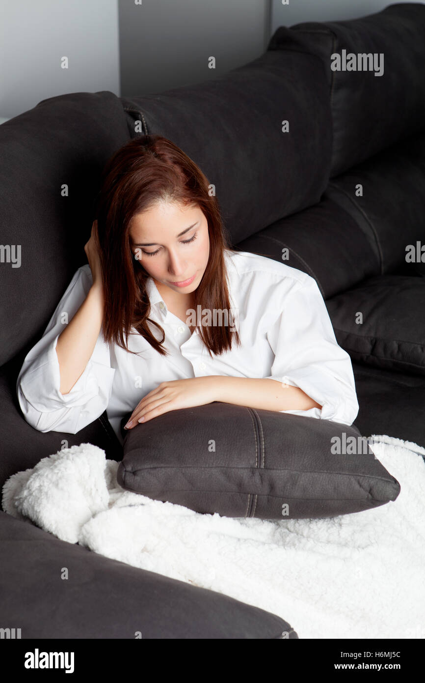 Sad young girl relaxing on couch at home Stock Photo - Alamy
