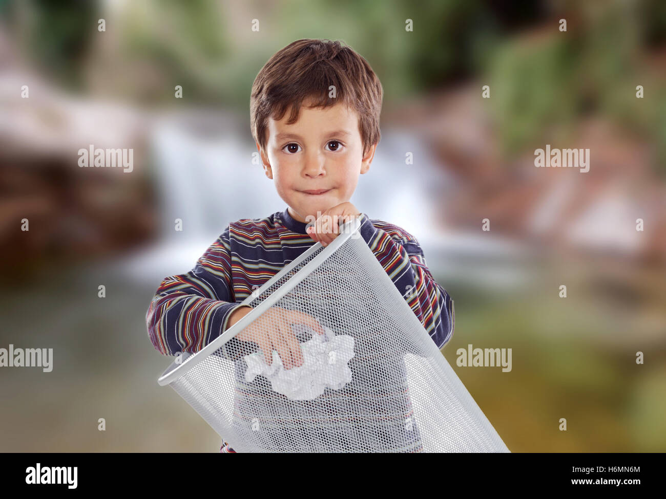 Little kid on the outside throwing a paper in the bin. Stock Photo