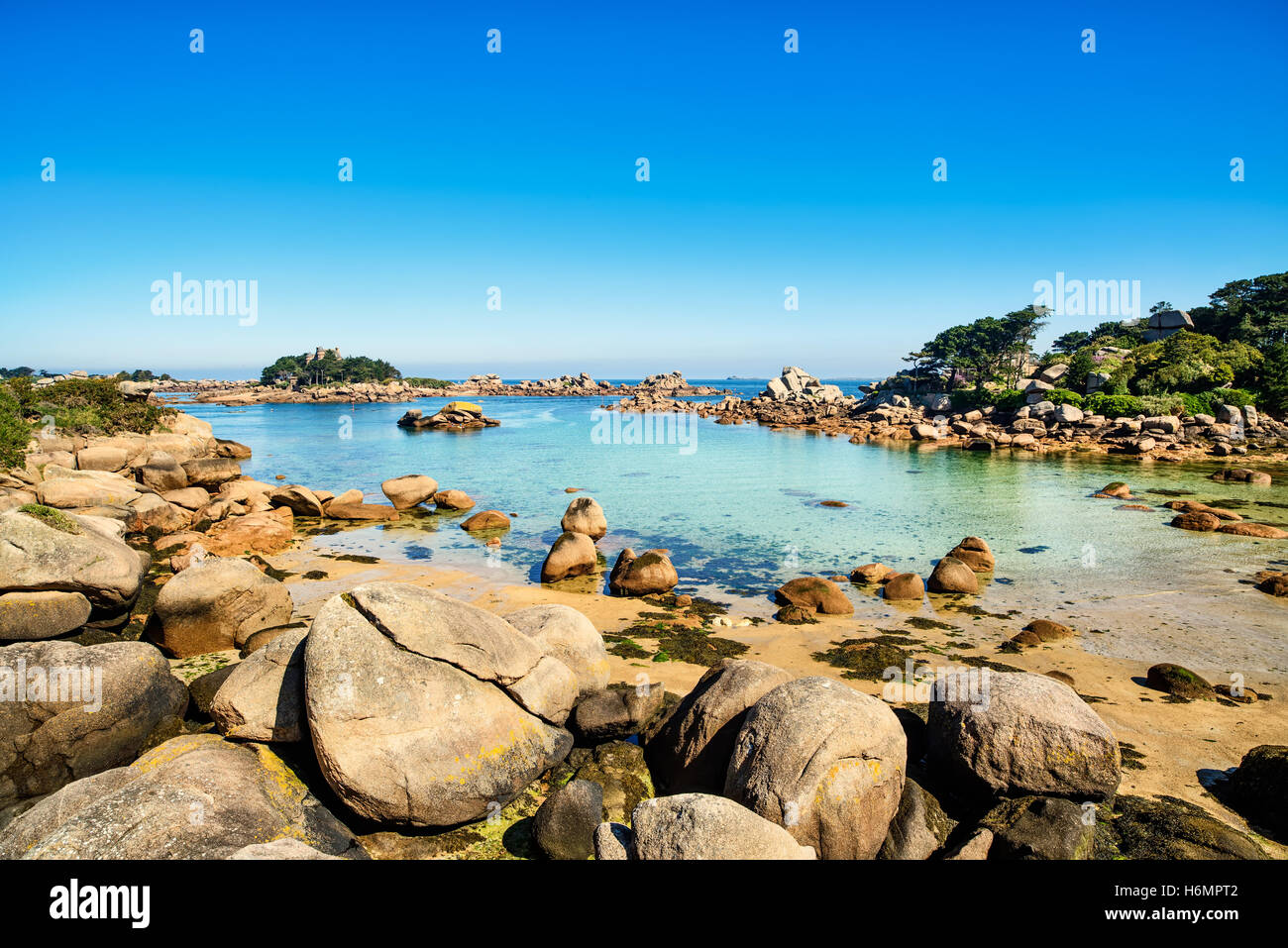 Ploumanach, rocks and bay beach in morning. Pink granite coast, Perros Guirec, Brittany, France. Stock Photo