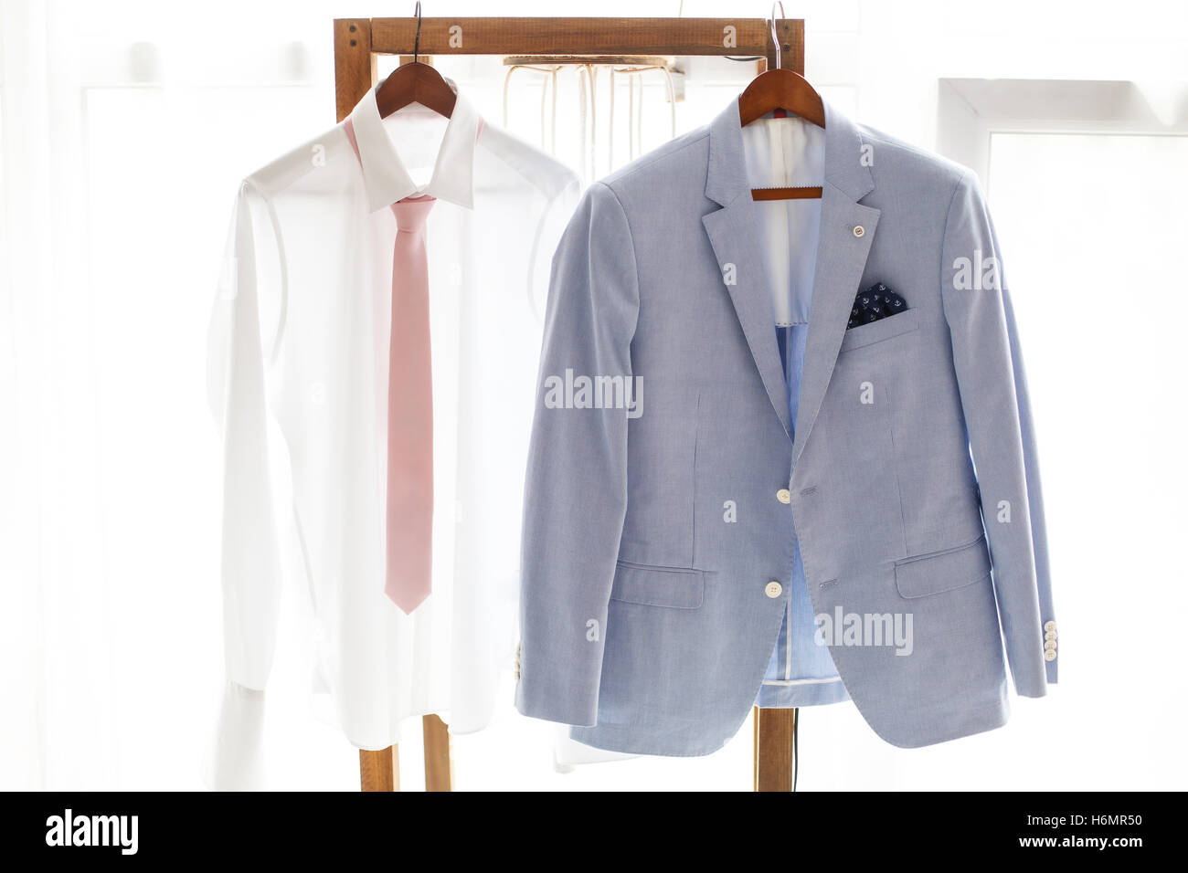 https://c8.alamy.com/comp/H6MR50/white-shirt-and-gray-suit-of-groom-hanging-on-hanger-H6MR50.jpg