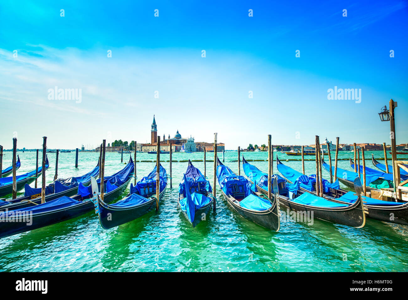 Venice, gondolas or gondole on a blue sky and San Giorgio Maggiore church landmark on background. Italy, Europe. Stock Photo