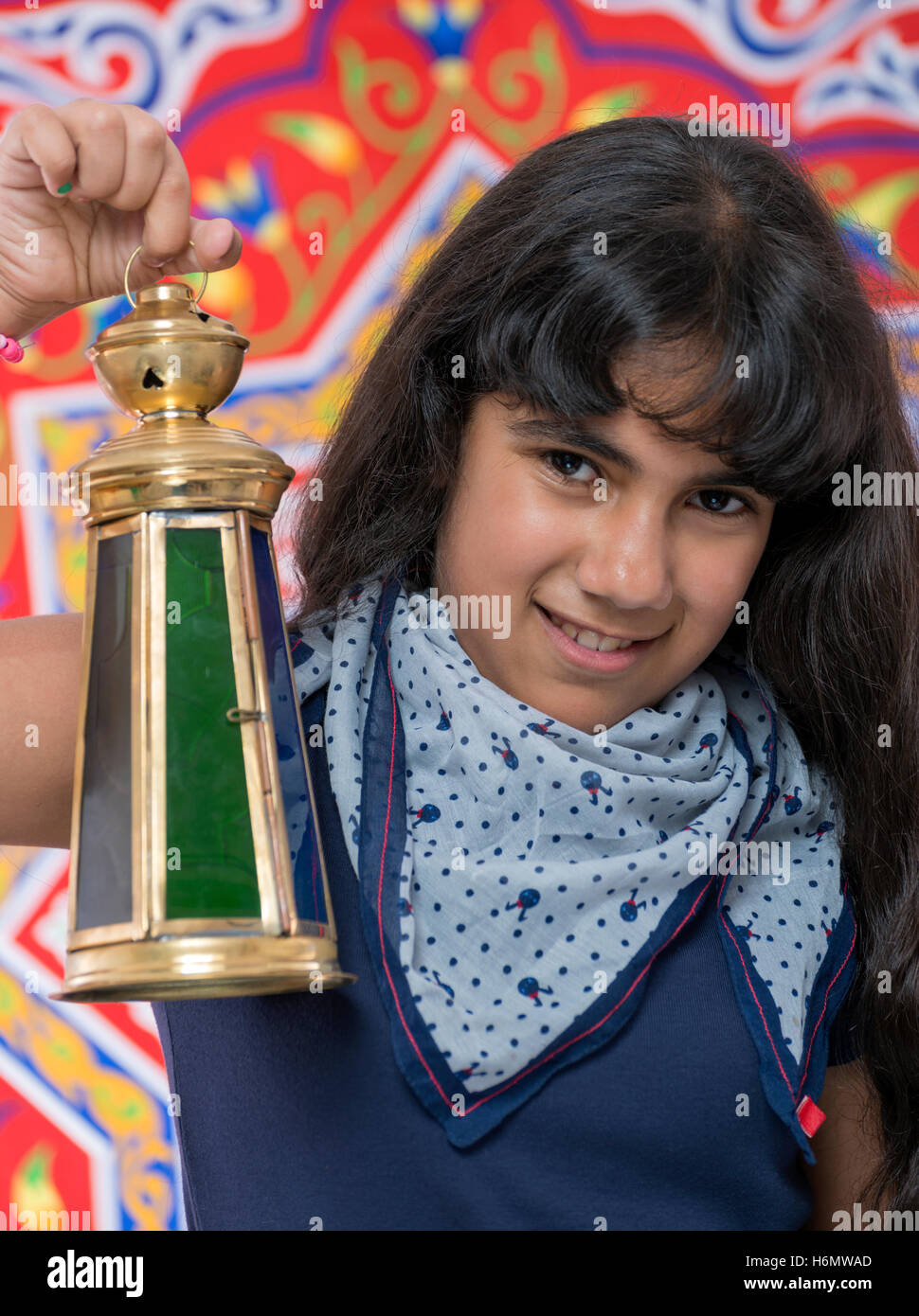 Happy Girl with Lantern Celebrating Ramadan over Ramadan Fabric Stock Photo