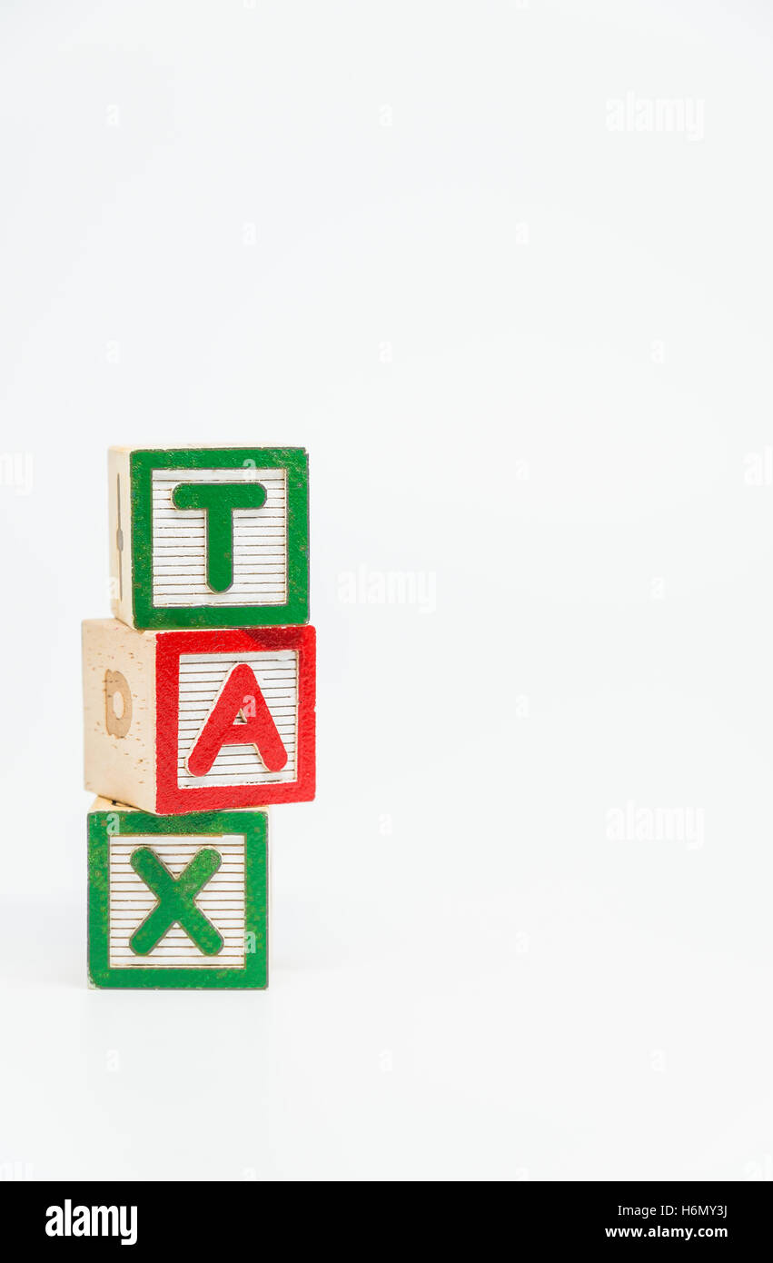 TAX word wooden block arrange in vertical style on white background and selective focus Stock Photo