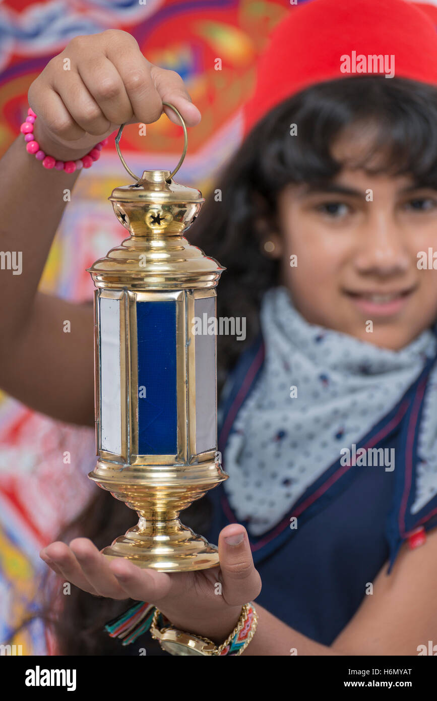 Happy Young Girl Holding Lantern Celebrating Ramadan over Ramadan Fabric Stock Photo