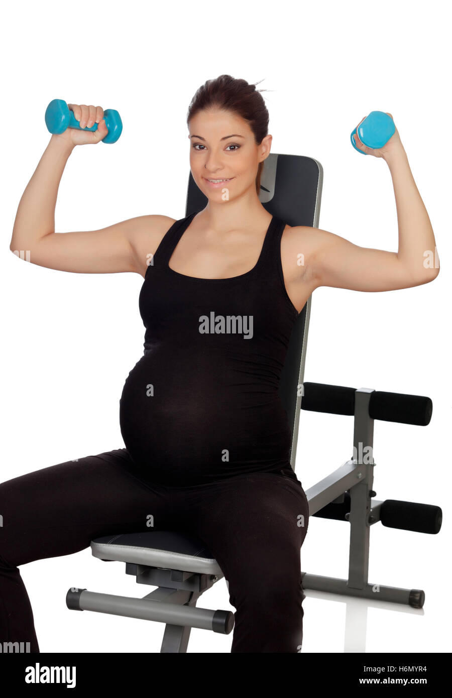 Pregnant woman lifting weights isolated on a white background Stock