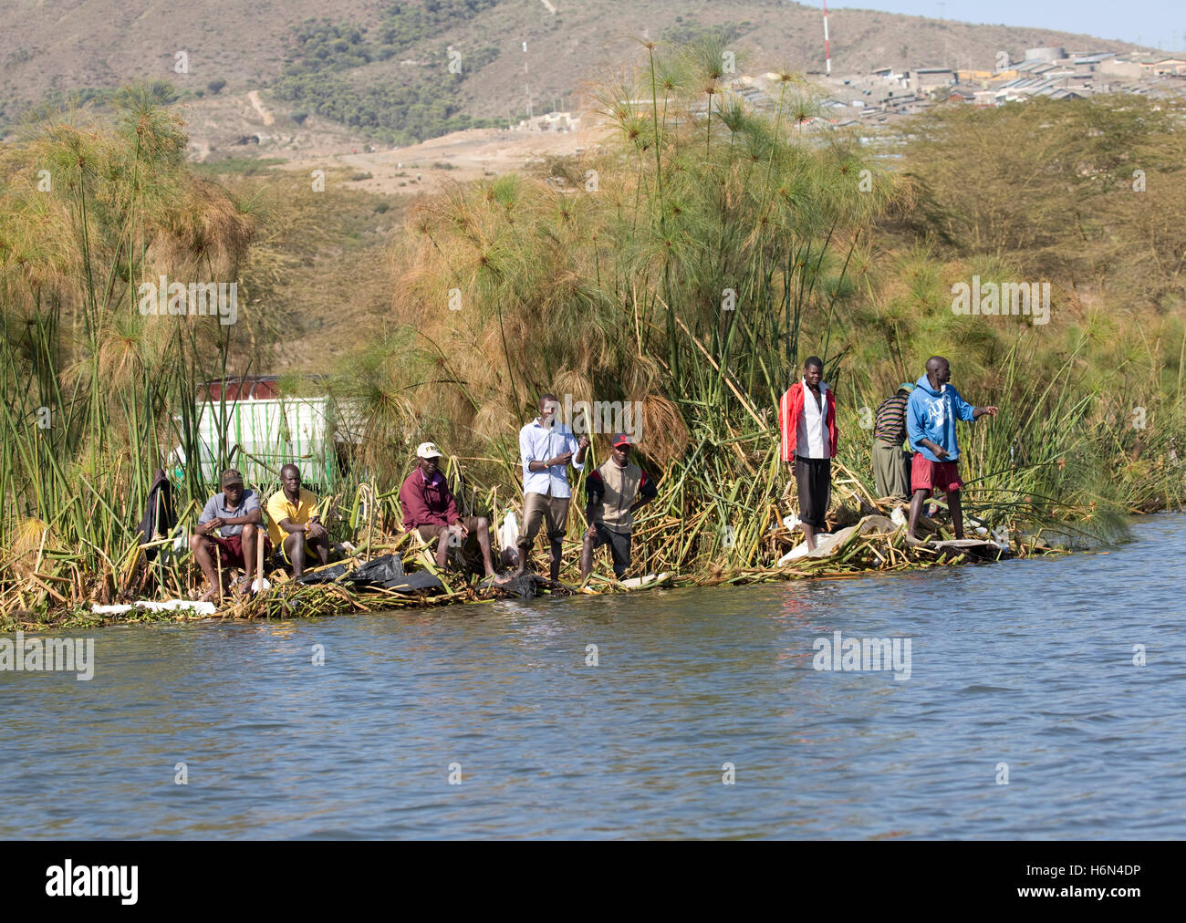 Local fisherman fishing with handlines from papyrus at edge of Lake Naivasha Kenya Stock Photo