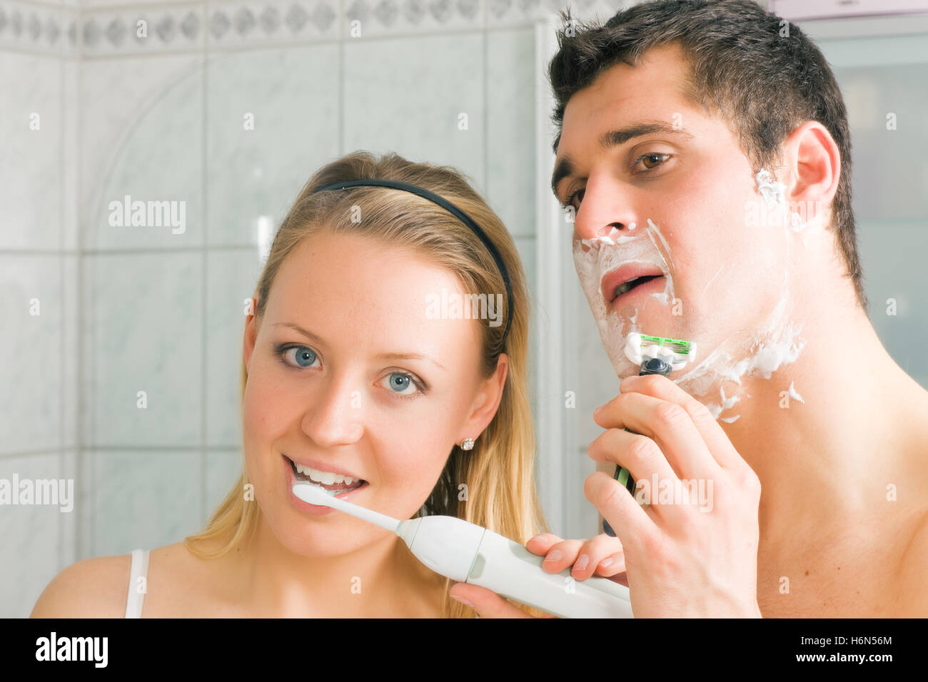 Мужчина и женщина чистят зубы. Чистка зубов электрической зубной щеткой. Девочка чистит зубы в ванной. Жена чистит зубы. Молодые бреются девушки.