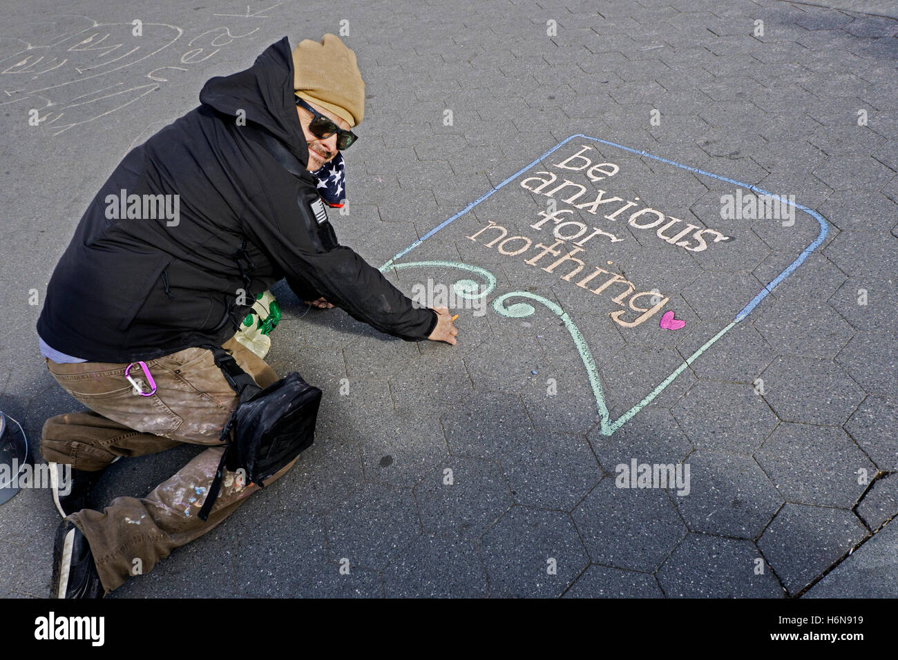 Street chalk artist Hans Ace Honschar with a finished piece in Washington Square Park in Greenwich Village, New York City. Stock Photo