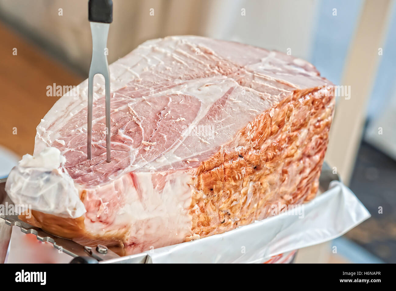 Close up of italian cooked ham ready to be sliced . Selective focus. Stock Photo
