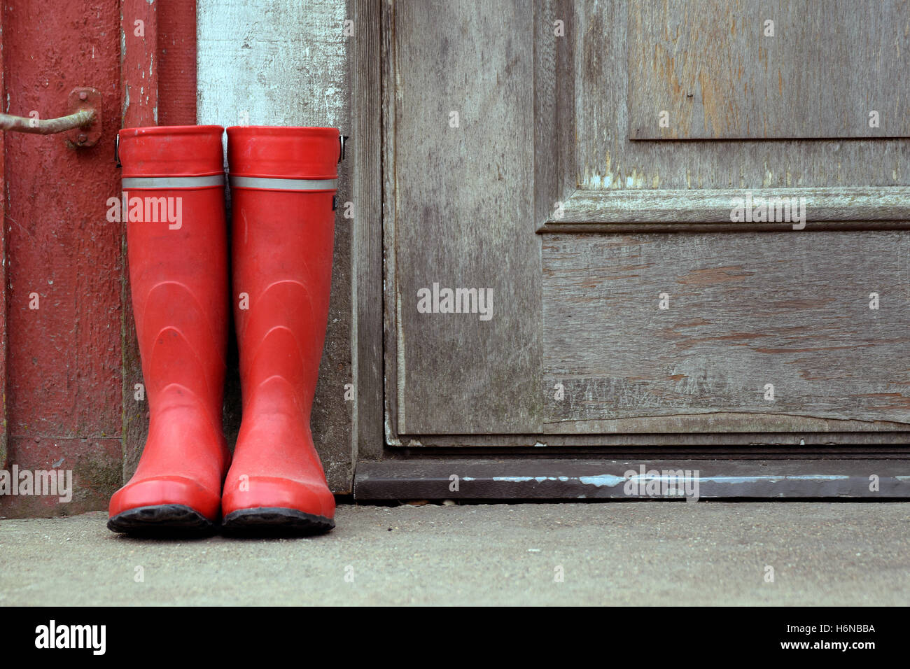 Red wellies outside of old house. Stock Photo