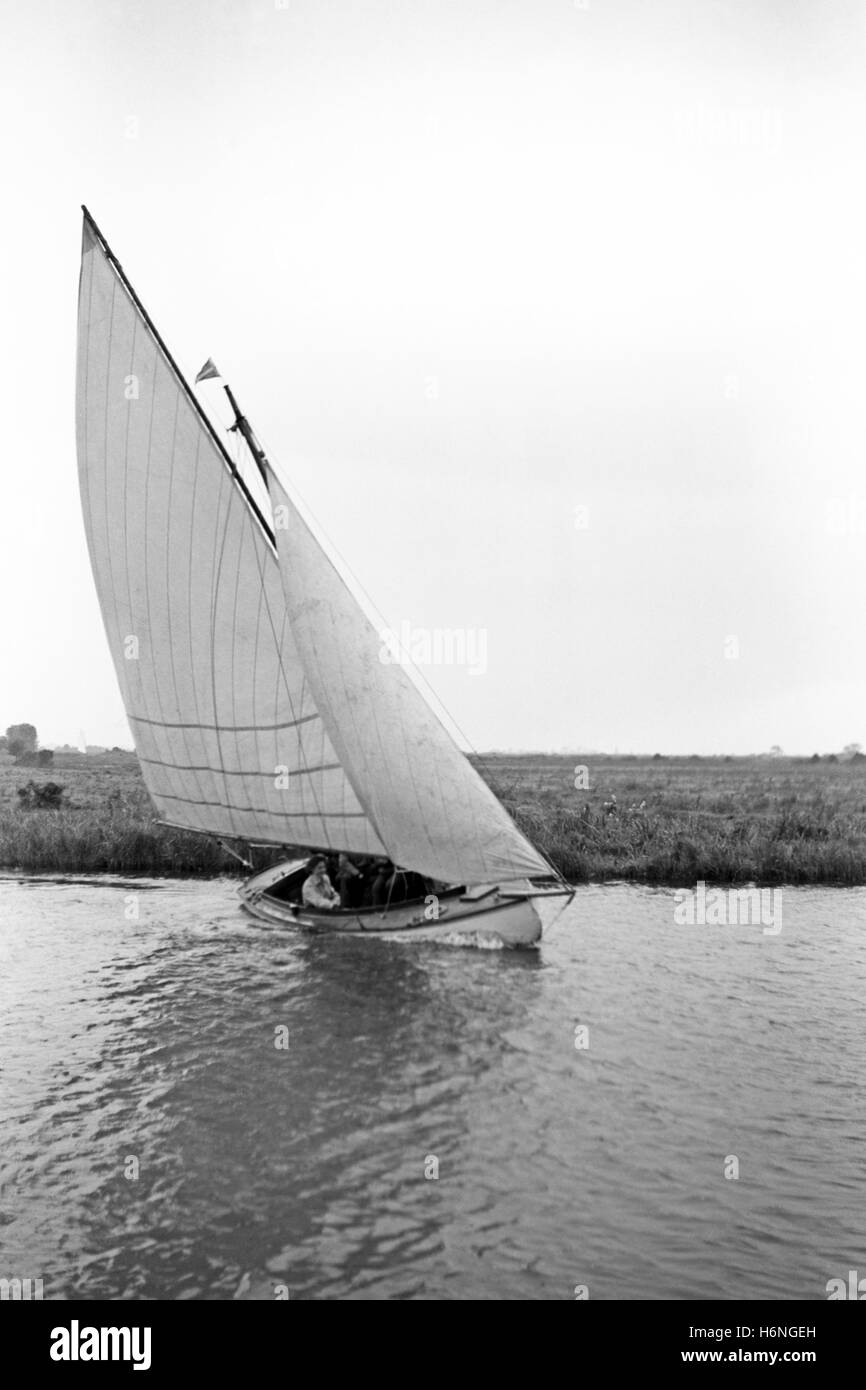 Small yacht sailing on river in Norfolk, England Stock Photo
