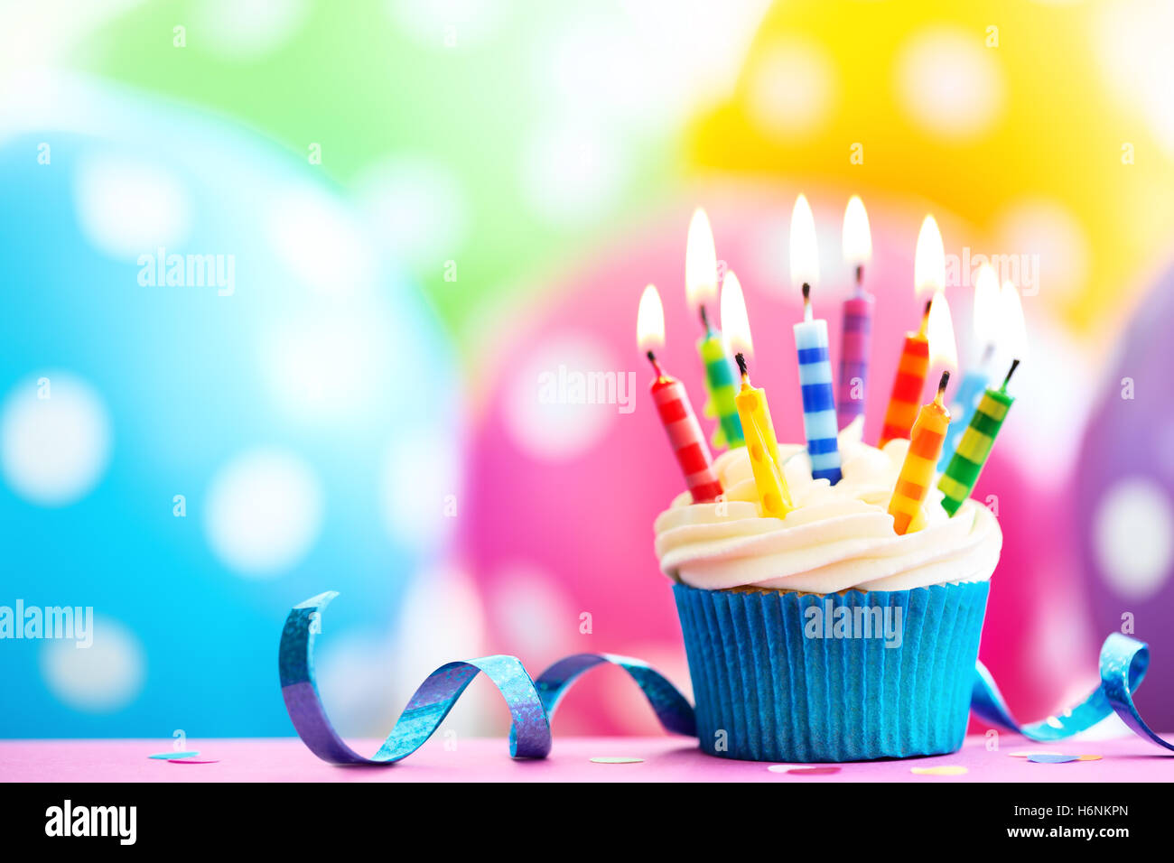 Cupcake decorated with colorful birthday candles Stock Photo