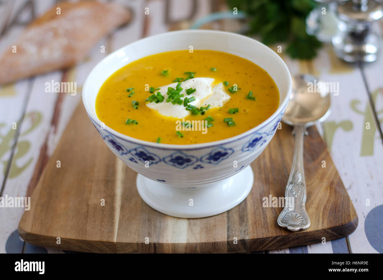 A bowl of vegetable soup with creme fraiche and chives Stock Photo