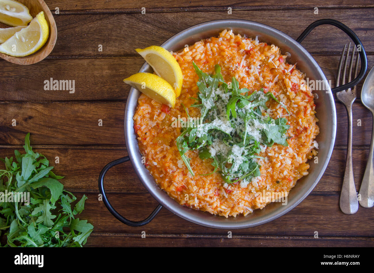 Red pepper risotto with Parmesan and rocket Stock Photo