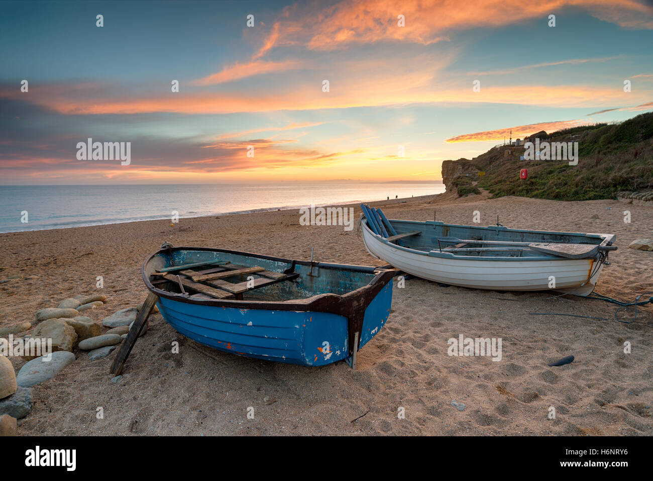 Stunning sunset over fishing boats on the beach at Burton Bradstock near Bridport on the Dorset coast Stock Photo