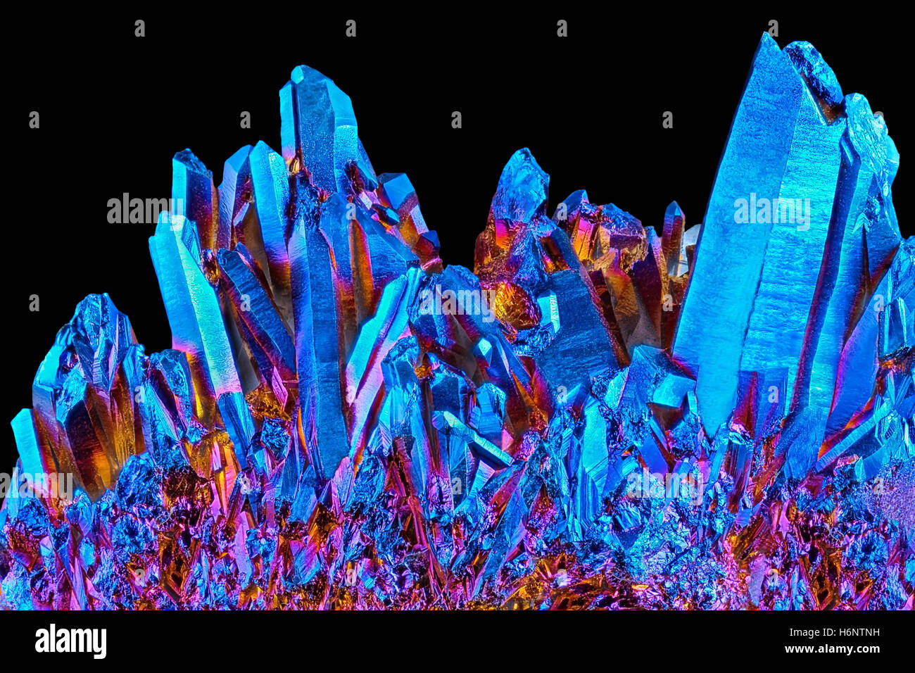 Amazing rare Quartz Rainbow Titanium aura crystal cluster on black background Stock Photo