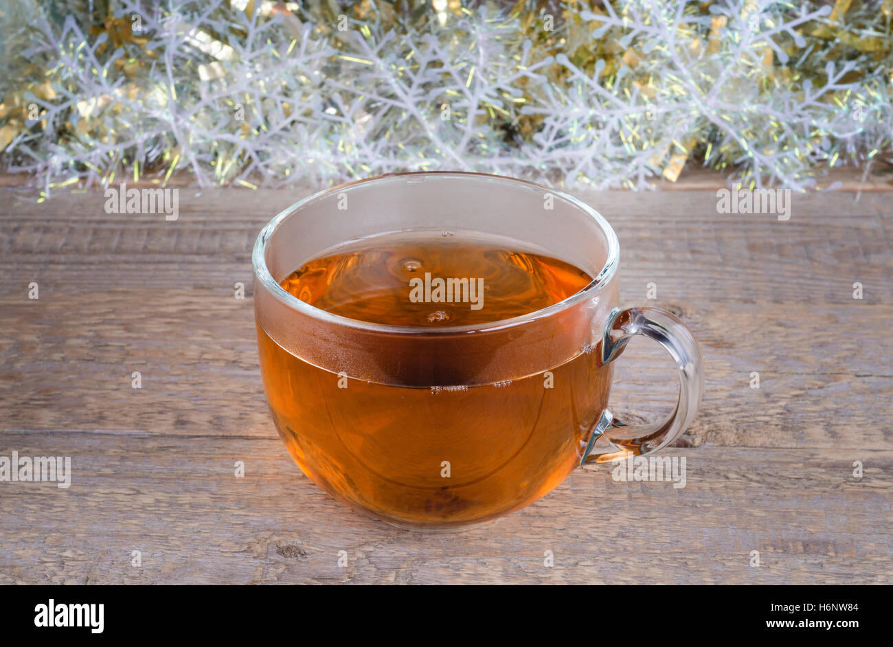 Cup of tea at Christmas background and old wooden surface. Stock Photo
