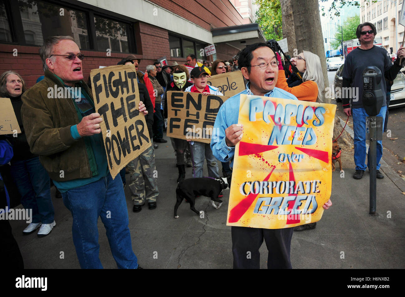 A group of activists holding a sign reading 'fight the power', 'end the fed' at a protest of big bank bailouts Stock Photo