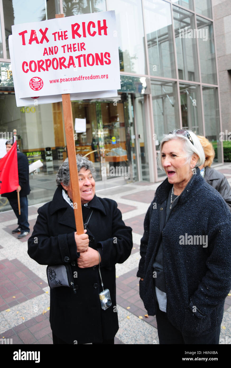 A activist holding a sign reading 'tax the rich and their corporations' at a protest of big banks,  protesting the bank bailout. Stock Photo