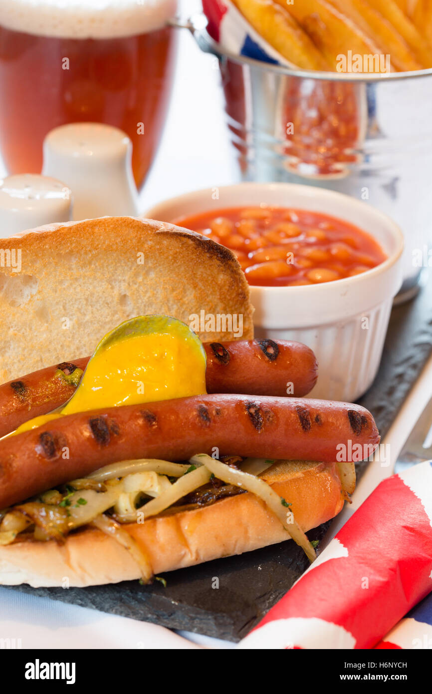 A meal/snack of English Hot Dog's served with Baked Beans and Chips