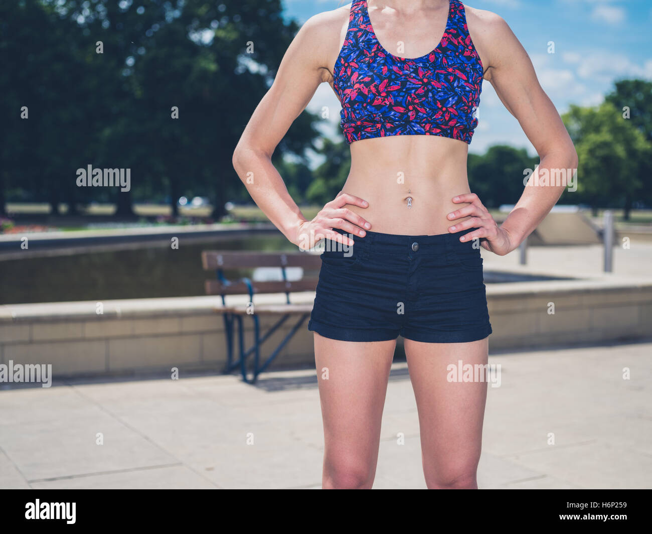 slim athletic woman torso abs belly wearing sportswear close up
