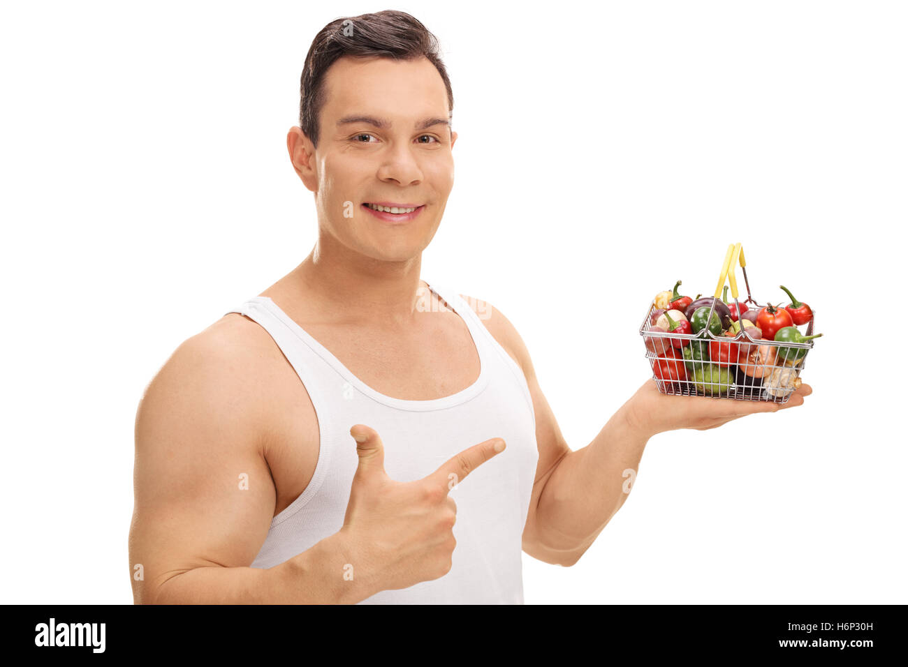 Cheerful man holding a small shopping basket full of fruits and ...