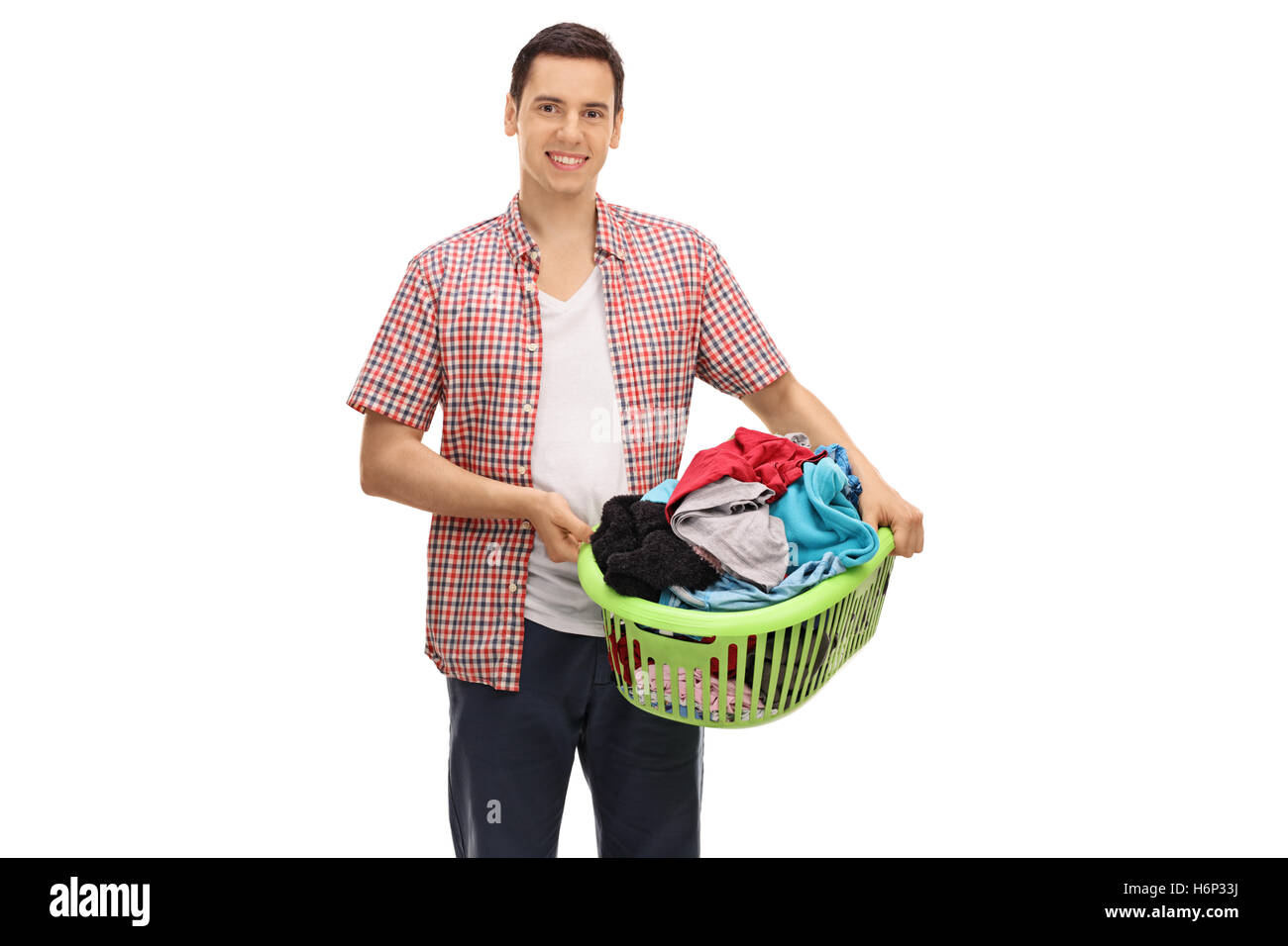 Young man holding a laundry basket full of clothes isolated on white background Stock Photo