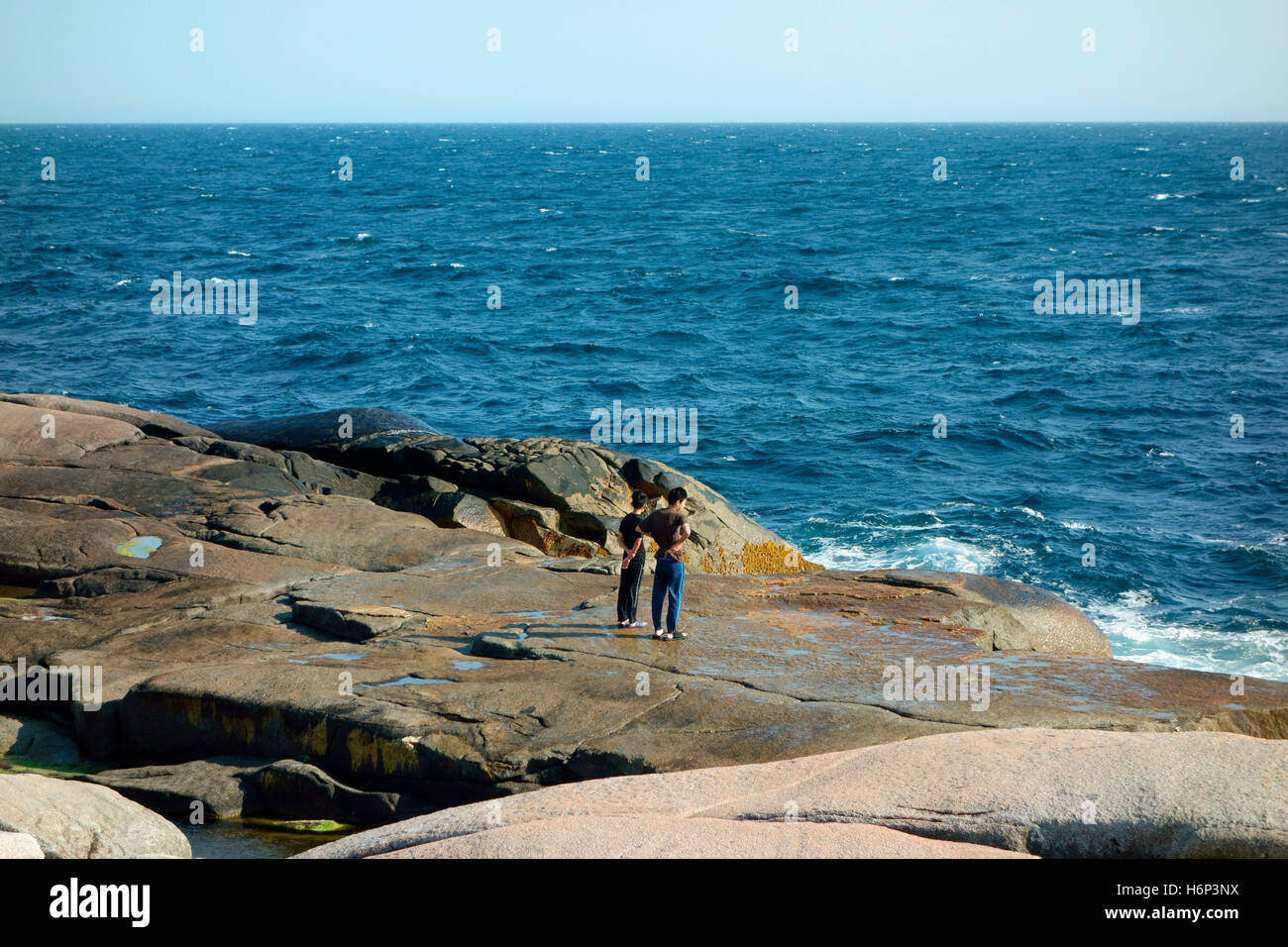 People in danger of being swept away by waves on the rocks at Peggy's
