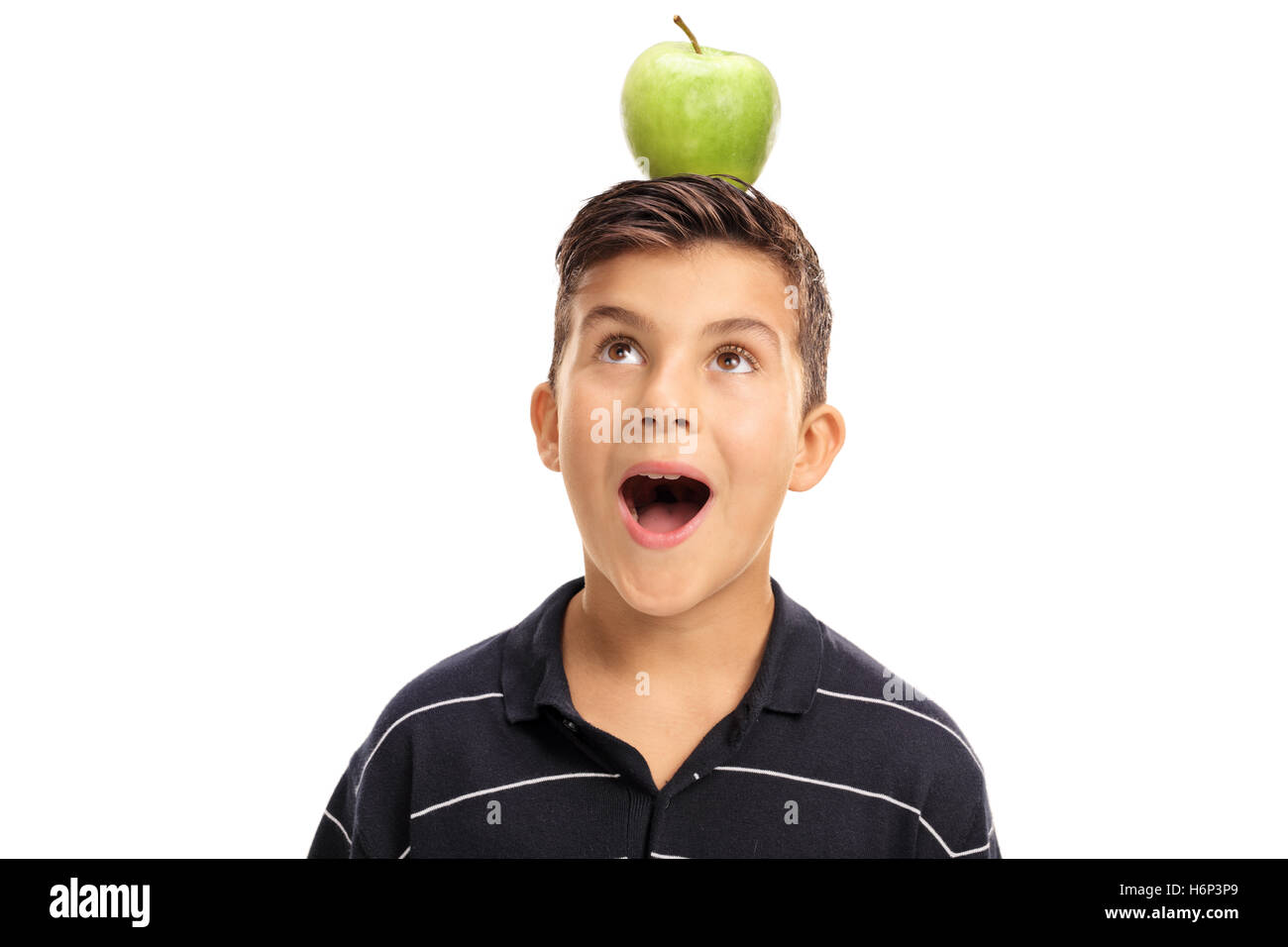 Overjoyed little boy looking at an apple on his head isolated on white background Stock Photo