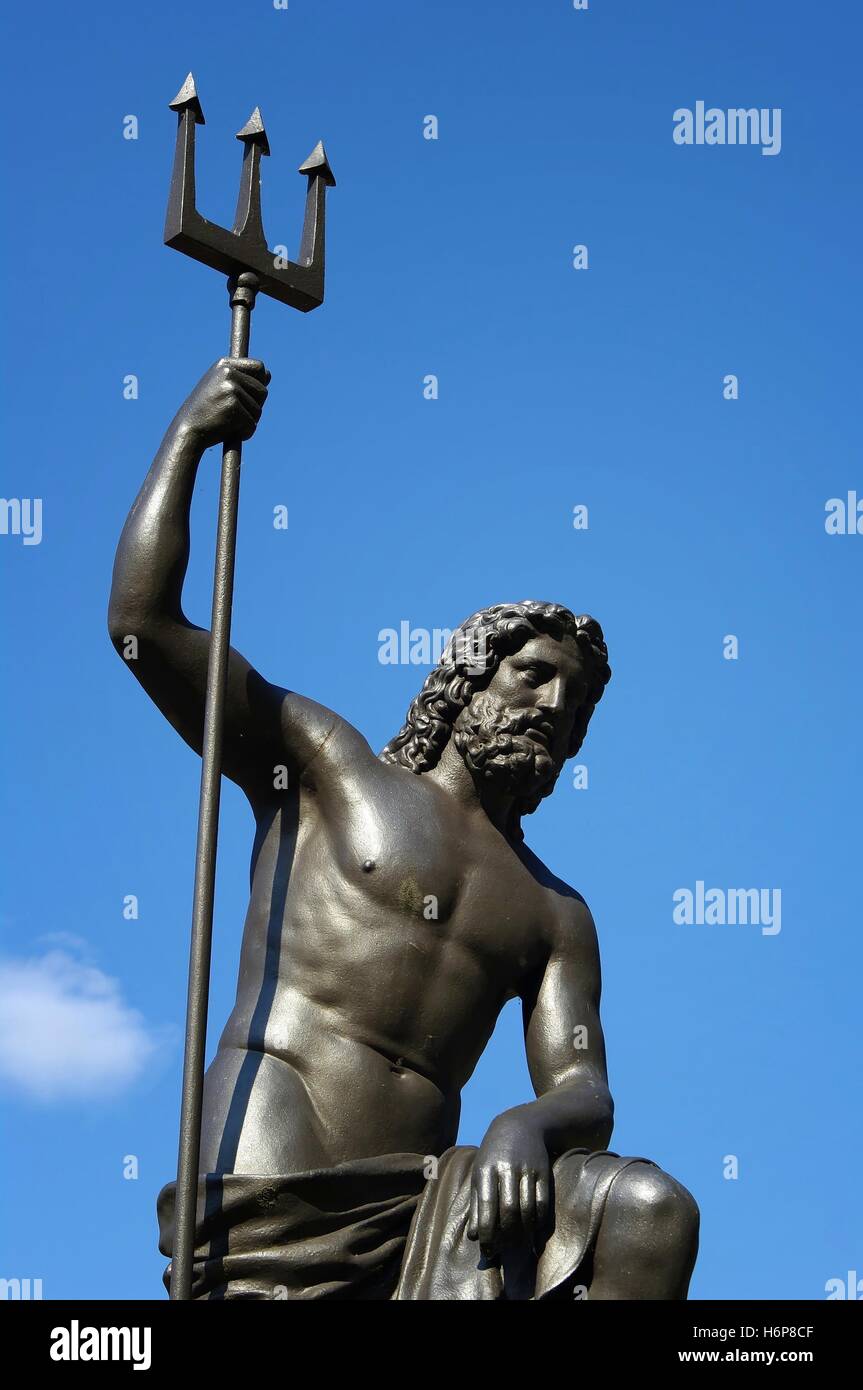 neptune statue with trident in front of sky Stock Photo