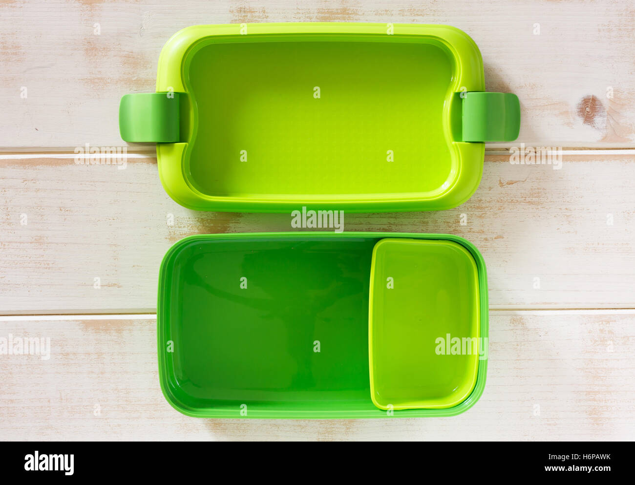 Green plastic lunch box on wooden background Stock Photo