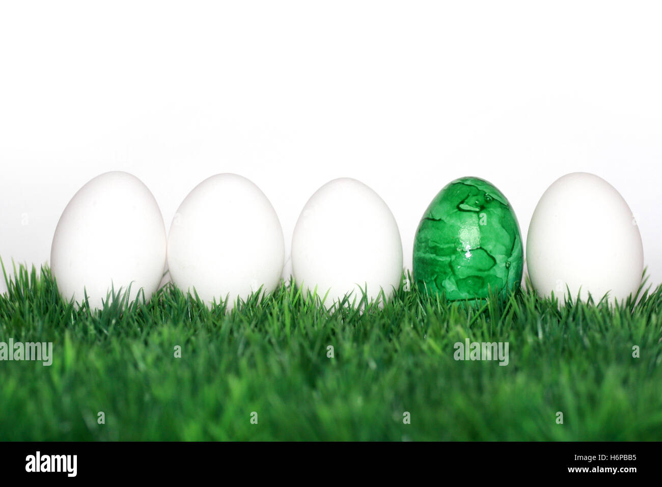 a green egg between white Stock Photo