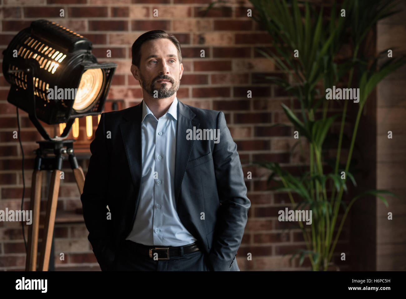 Successful confident man putting hands in his pockets Stock Photo