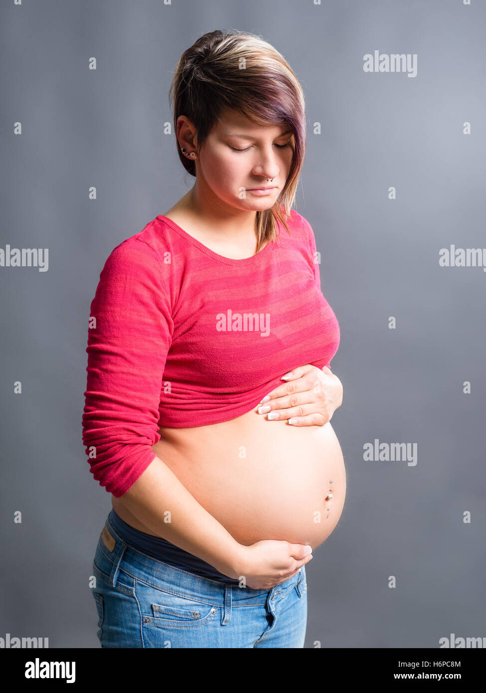 Pregnant woman holding belly in pain hi-res stock photography and