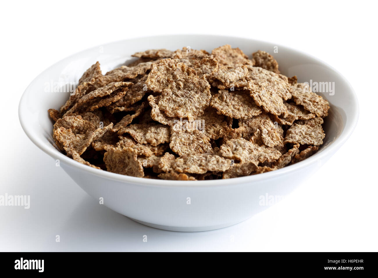Wheat bran breakfast cereal with no milk in a bowl isolated on white background. Stock Photo