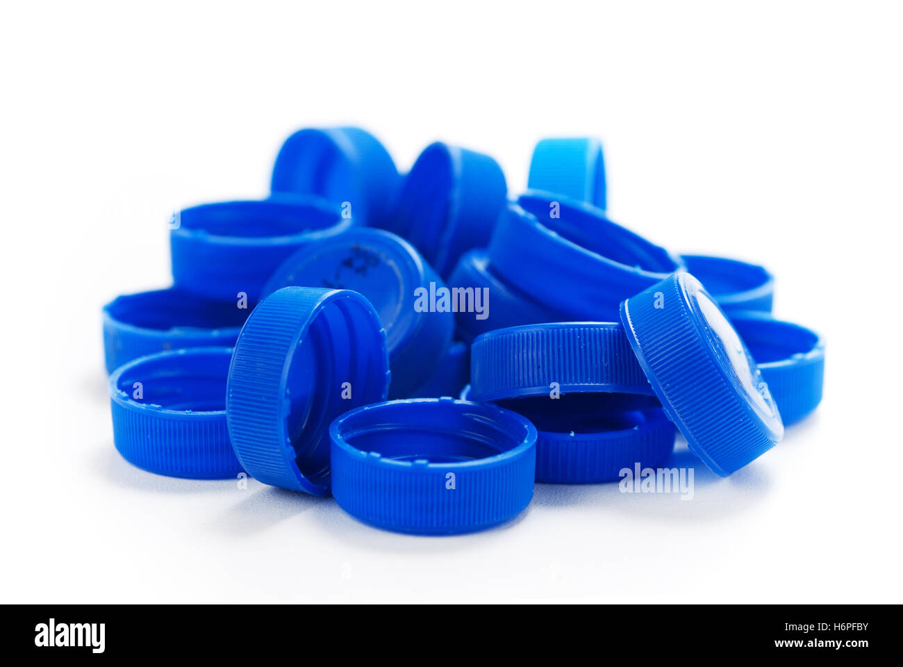 blue bottle cap plastic synthetic material used recycling heap pile backdrop background white recycle Stock Photo