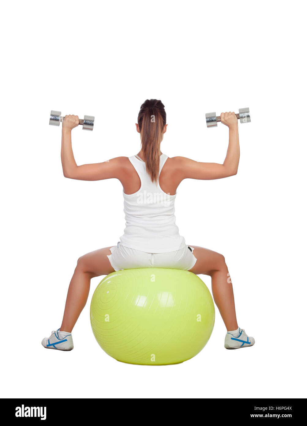 Attractive girl lifting weights sitting on a ball isolated on white background Stock Photo