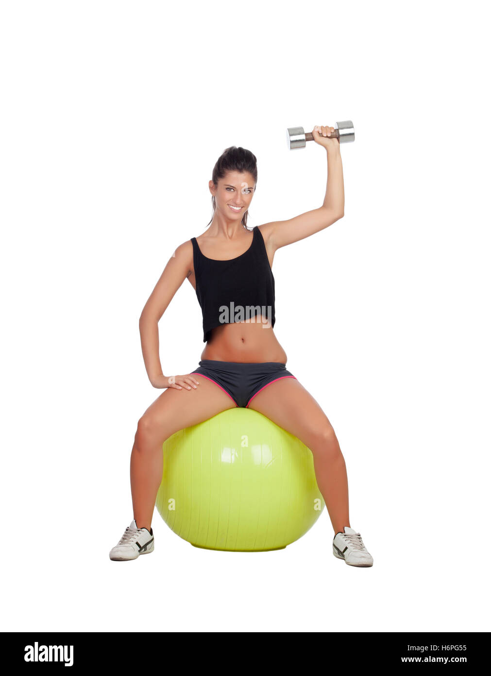 Attractive girl lifting weights sitting on a ball isolated on white background Stock Photo
