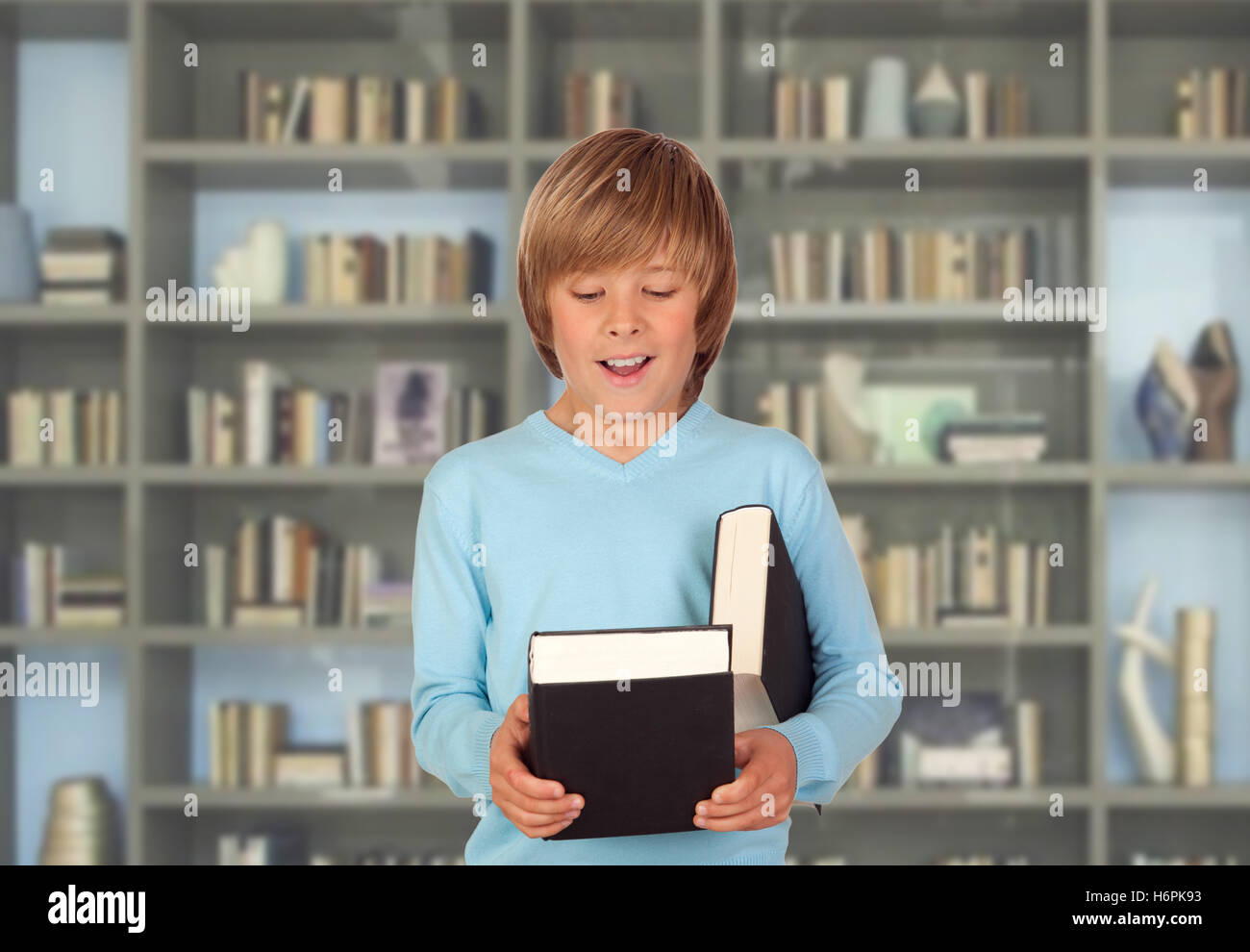 Preteen boy with books for reading in the library Stock Photo - Alamy