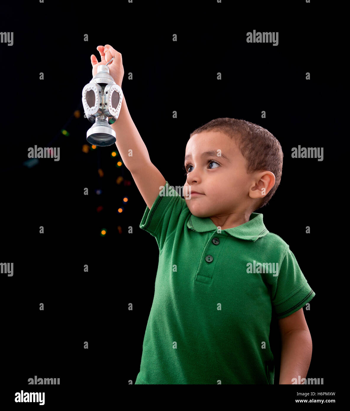 Happy Little Child with Ramadan Lantern on Defocused Night Lights Background Stock Photo