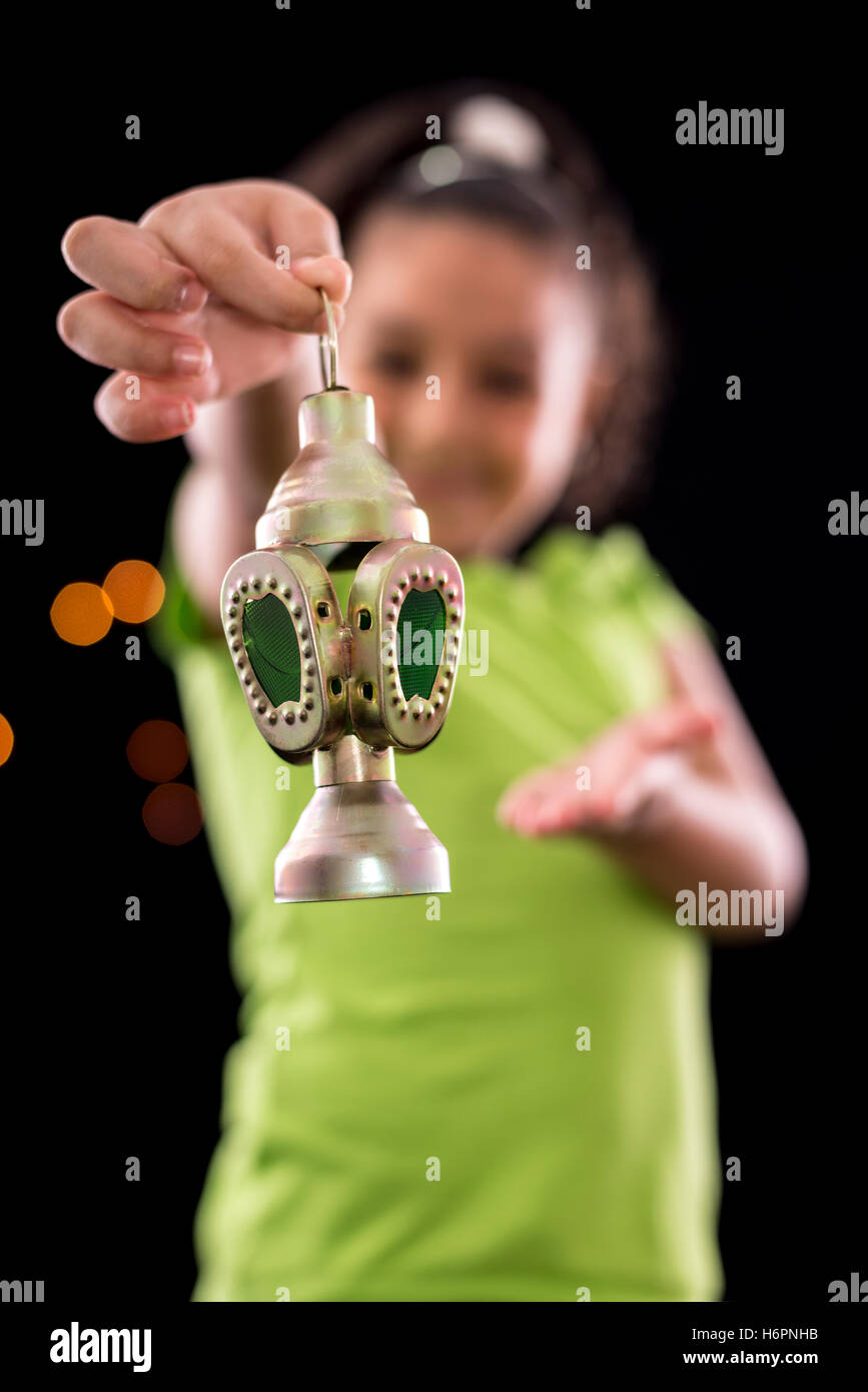 Happy Girl with Ramadan Lantern on Defocused Night Lights Background Stock Photo