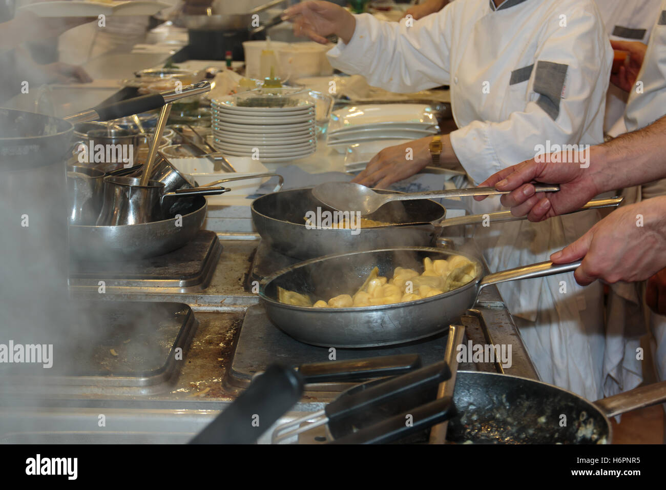 Cooking inside Restaurant's Kitchen, Pans, Dishes and Chef with Uniform