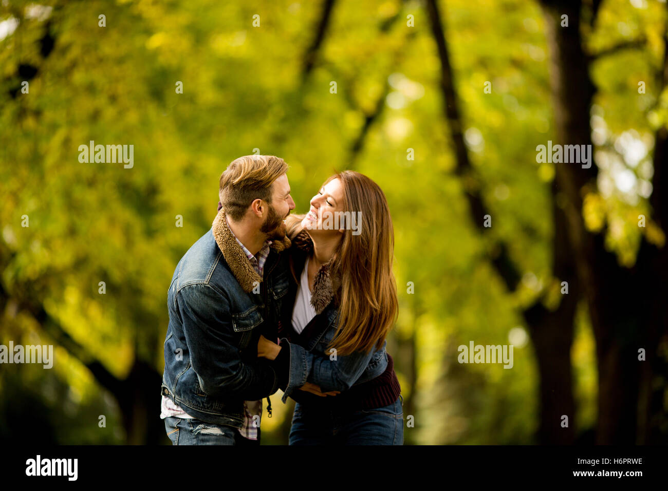 Young couple having fun in the autumn park Stock Photo - Alamy