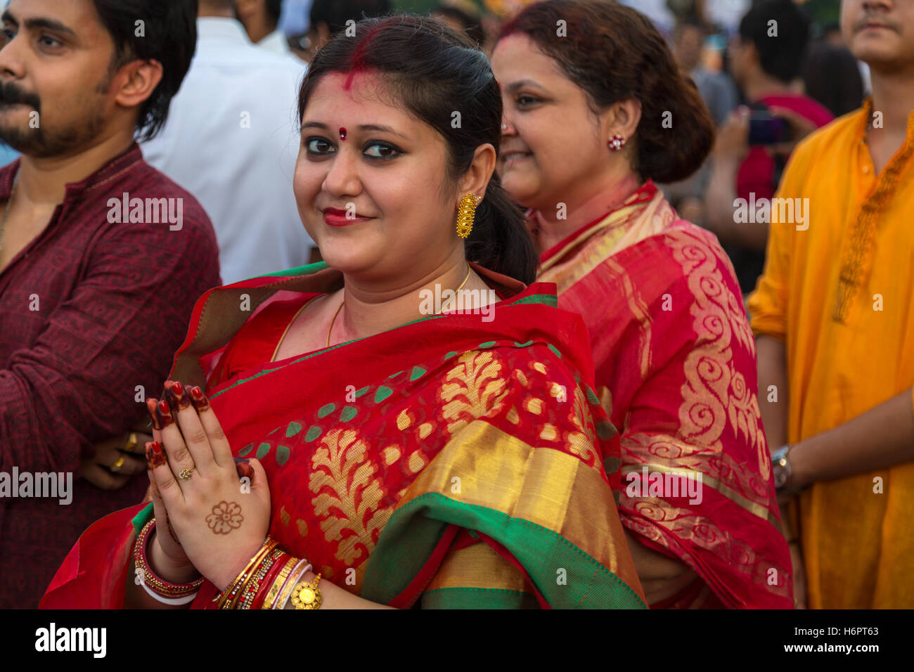 A hindu married woman holds her hands to pay homage to Goddess Durga at the  immersion ceremony at Babughat, Kolkata. Stock Photo